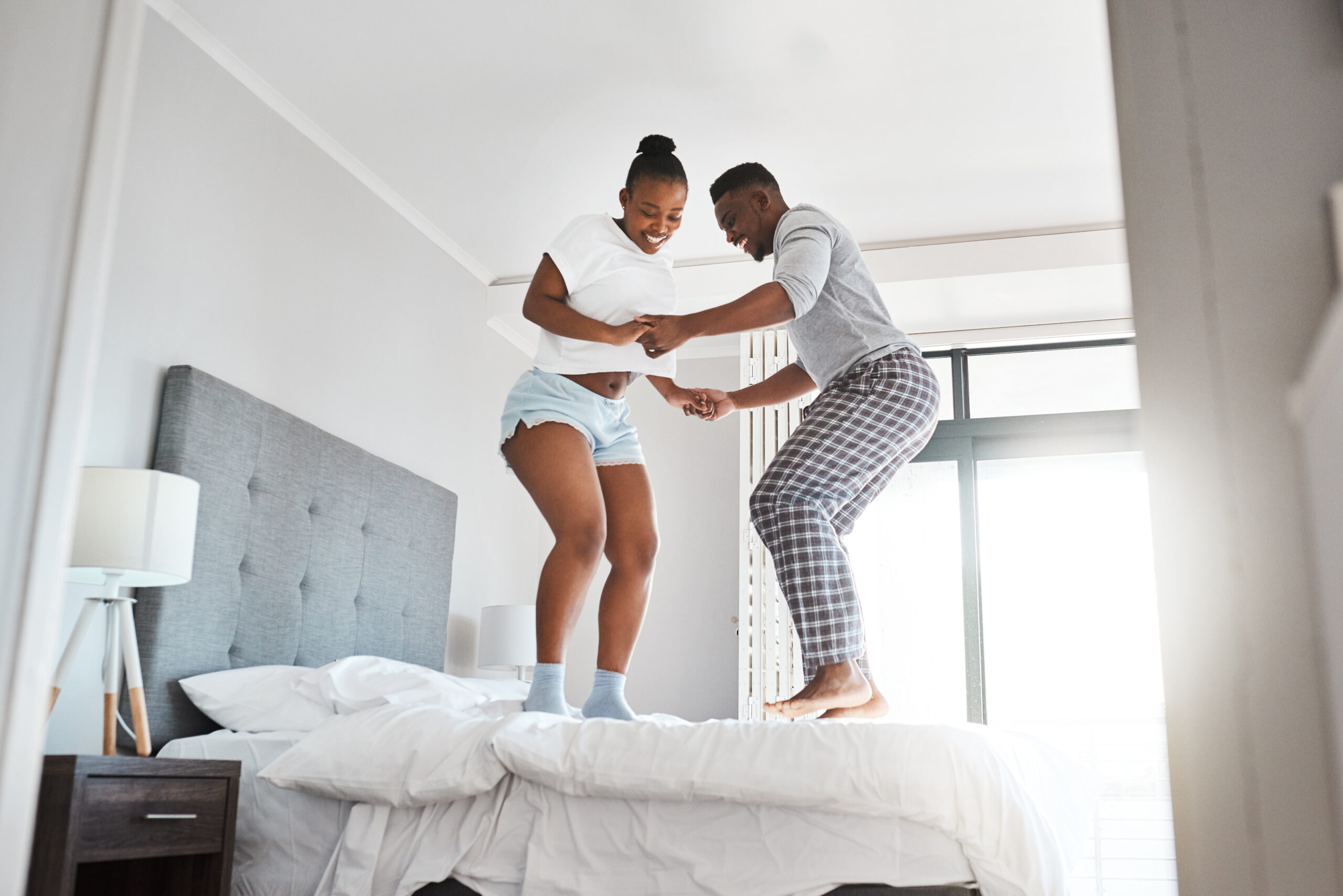 couple jumping on bed