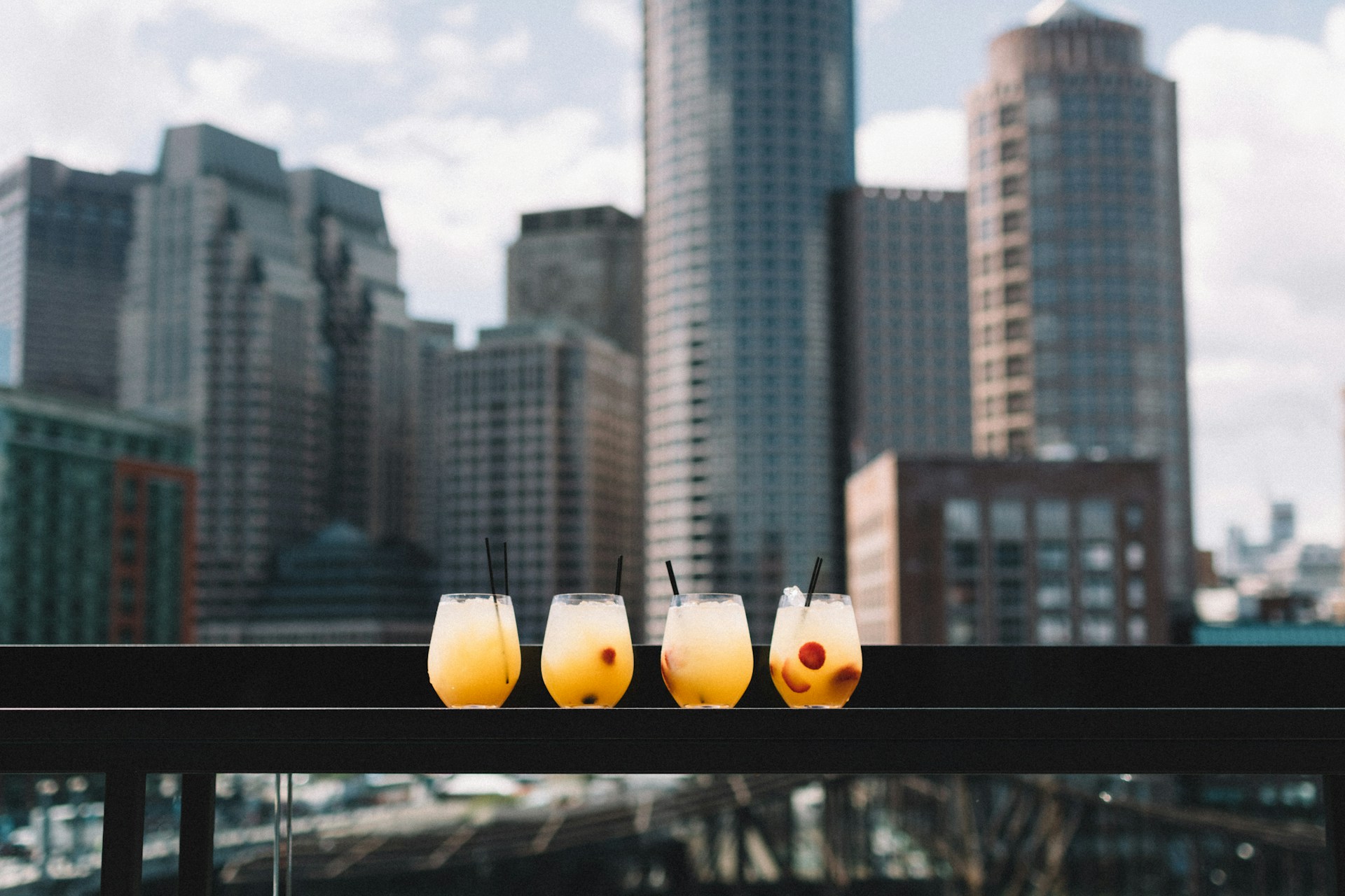 Four cups of sangria on a balcony in the city. 