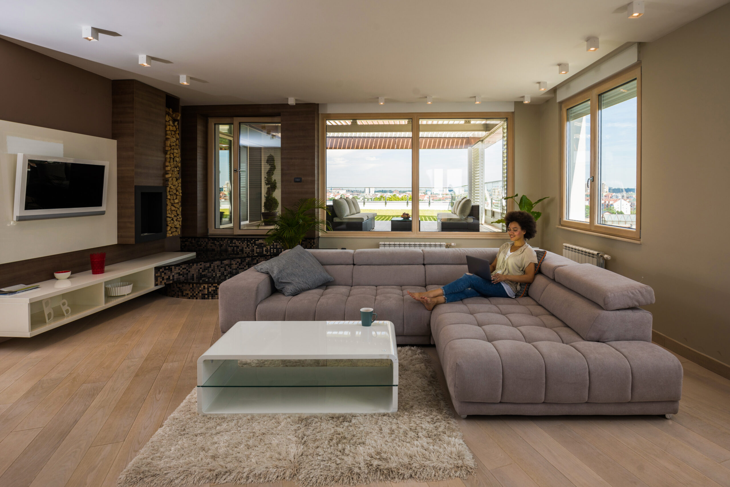 woman sitting in living room with tv mounted on wall