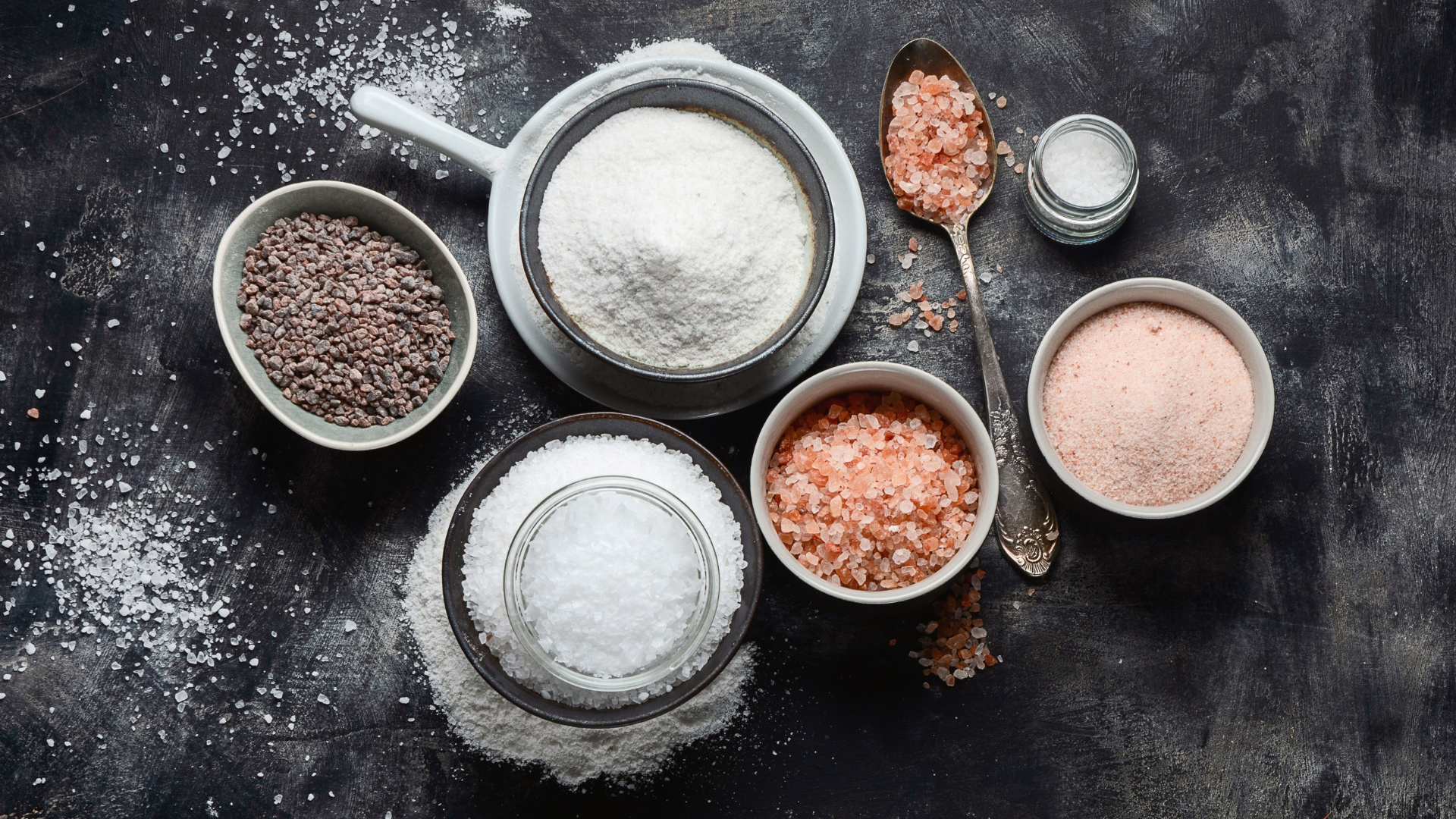 top view of various cooking salts on black background