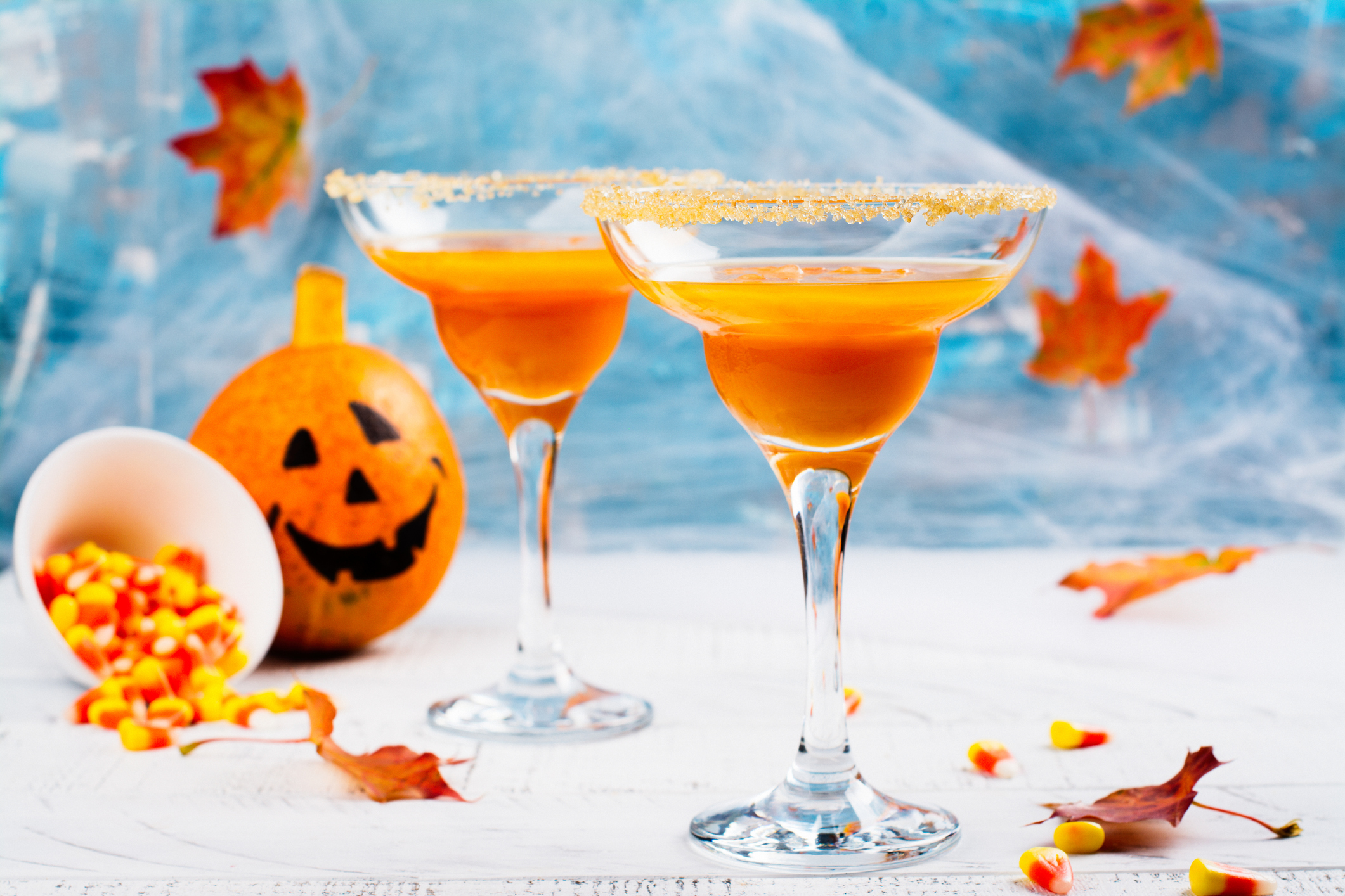 Autumn pumpkin Halloween martini cocktail with halloween decor on wooden table.