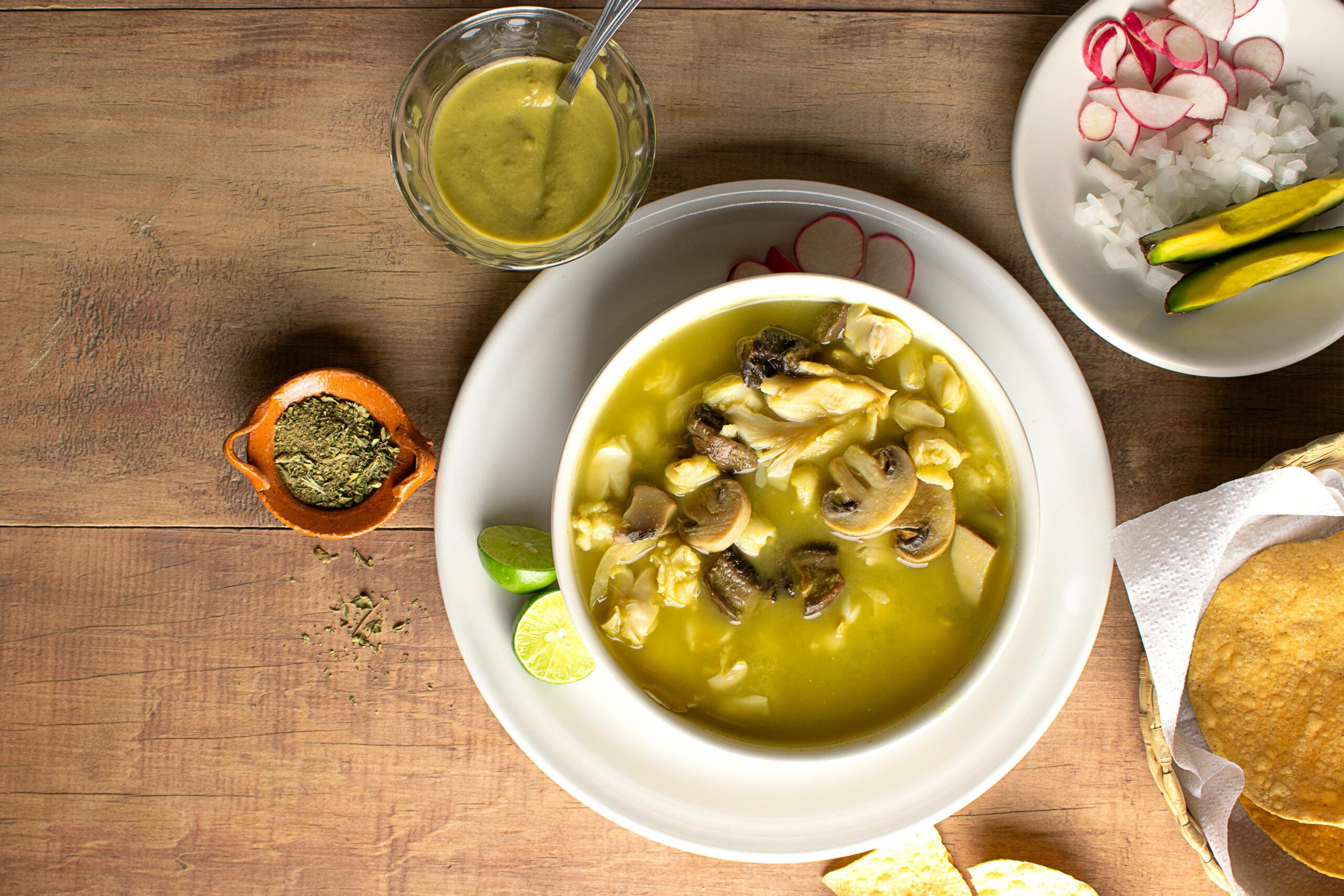 a bowl of pozole verde topped with mushrooms 