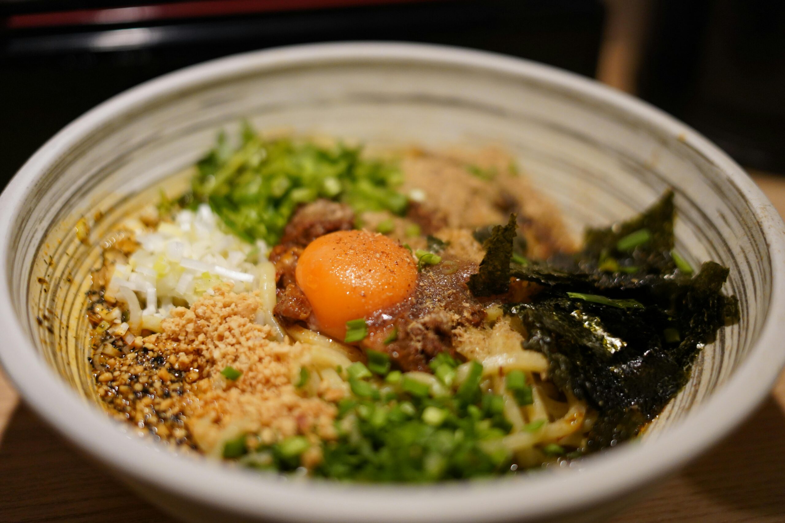 a bowl of ramen topped with greens, an egg