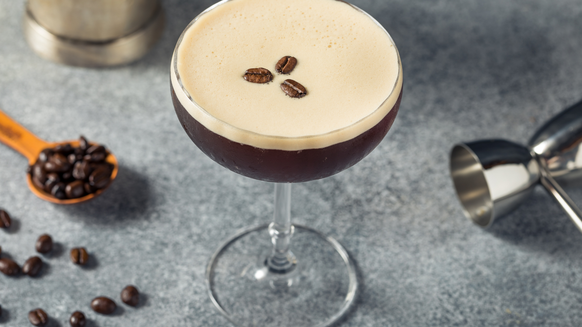 Espresso Martini Cocktail display with raw coffee beans and jigger