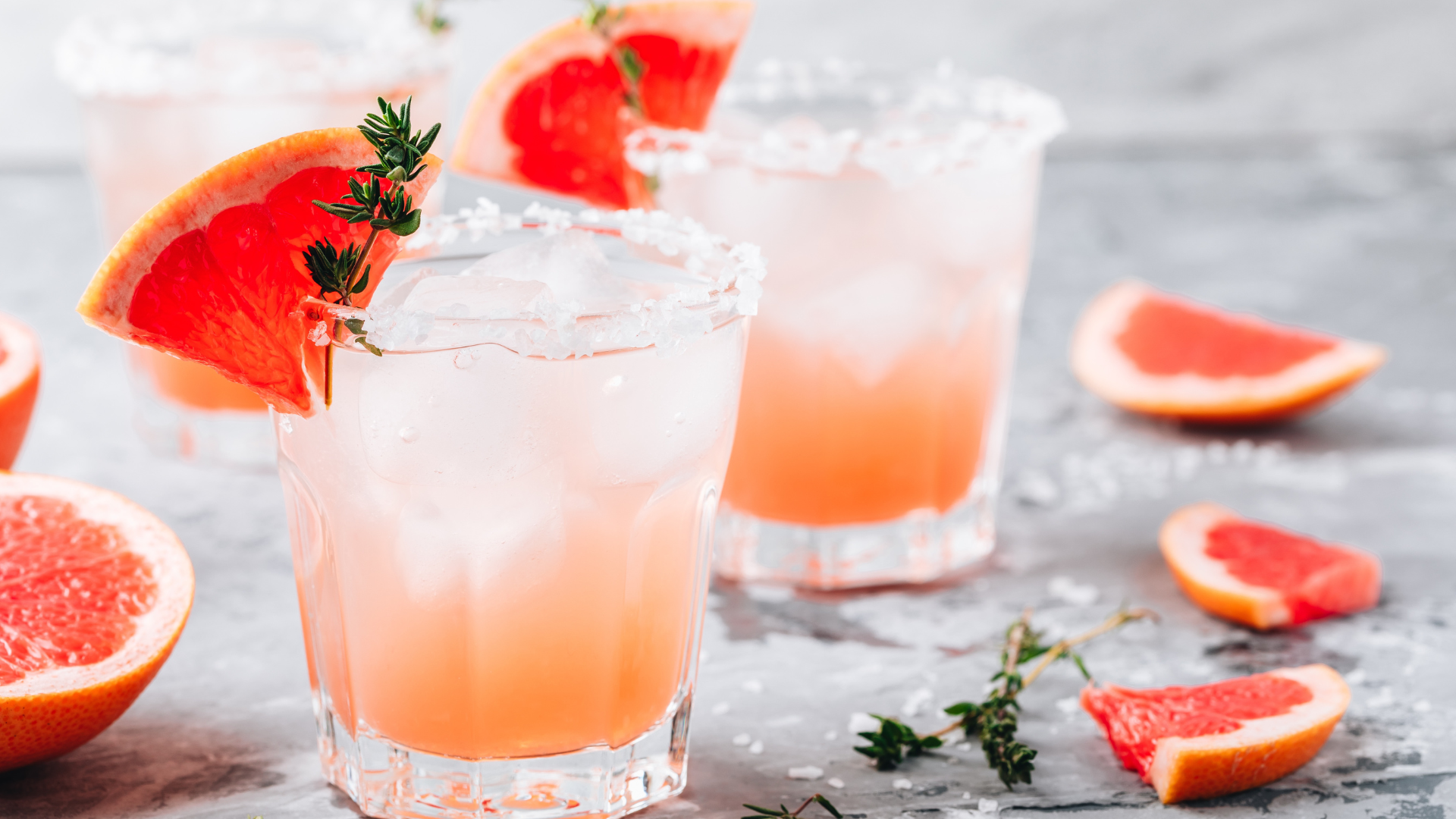 Grapefruit salty dog Cocktail with ice in glass on gray table