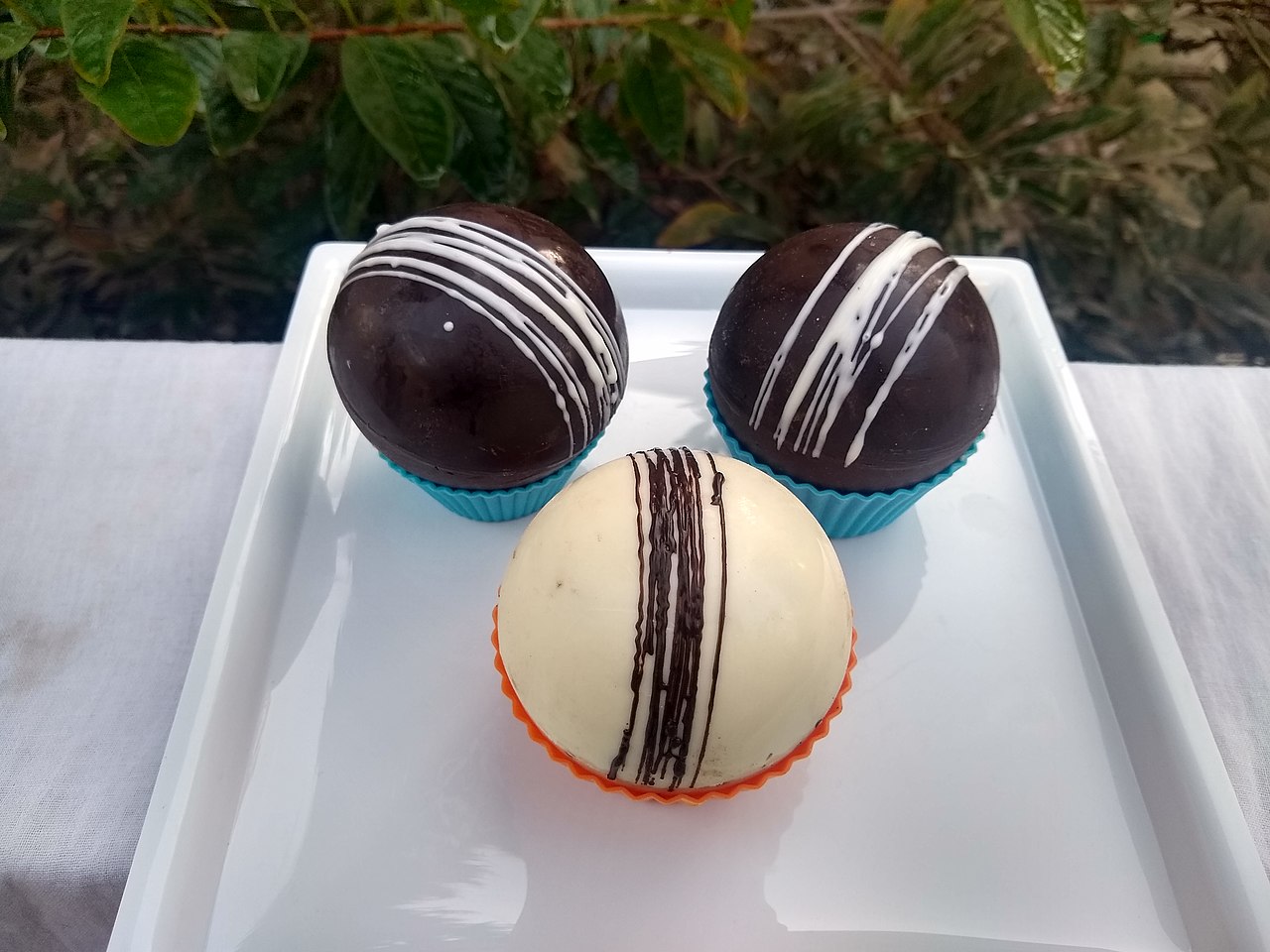 White and brown chocolate bombs on a plate