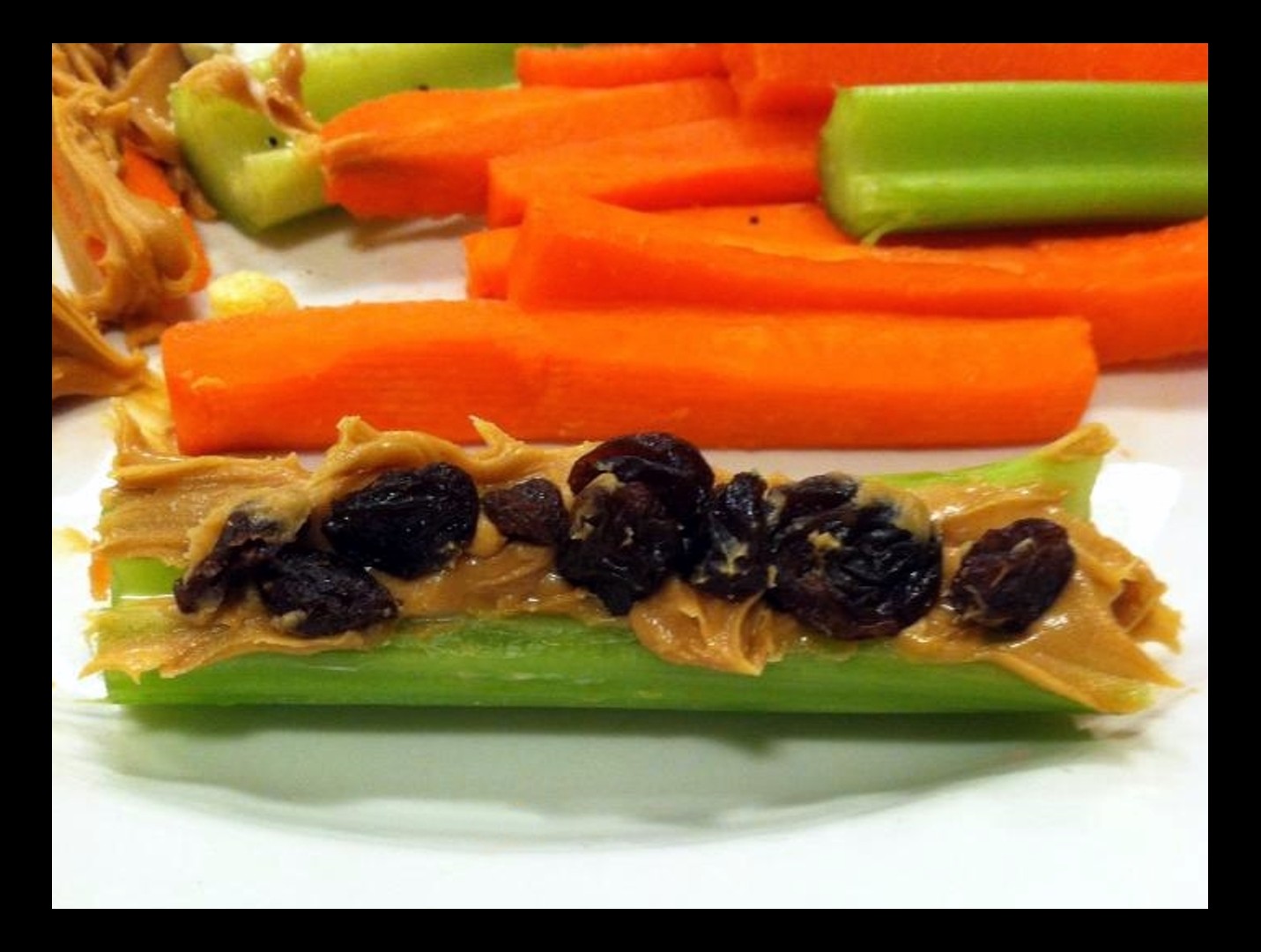 Peanut butter and raisins on celery stick