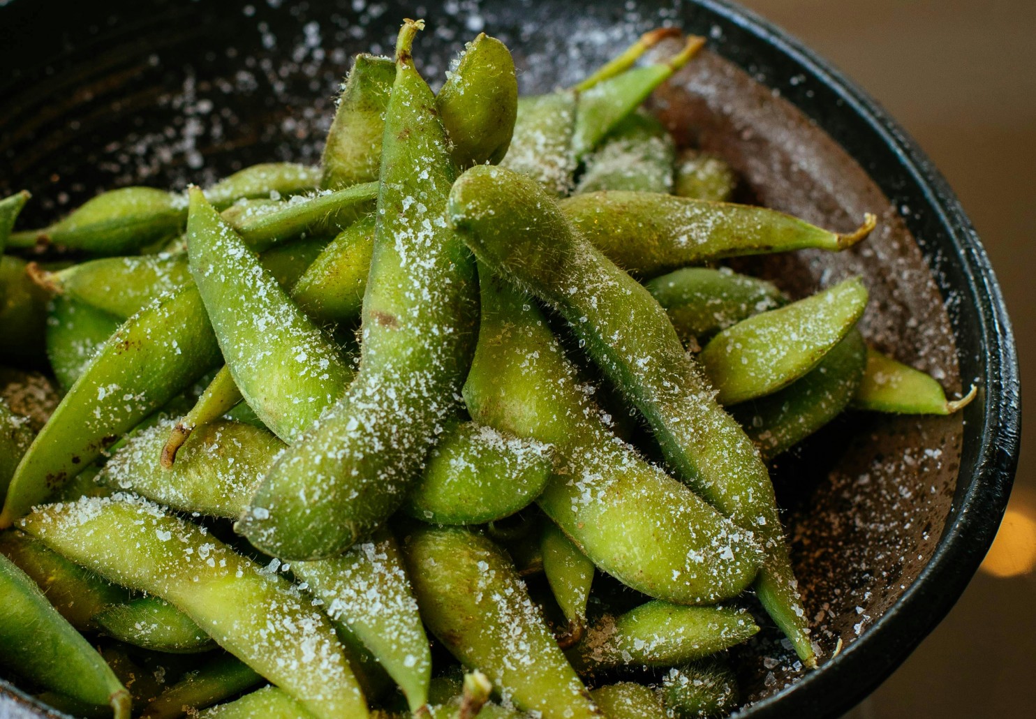 Edamame with salt on black plate