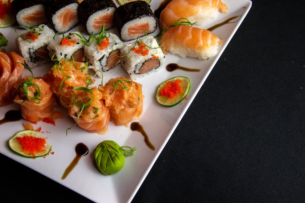 Wasabi and soy sauce at the center of the plate with various sushi rolls