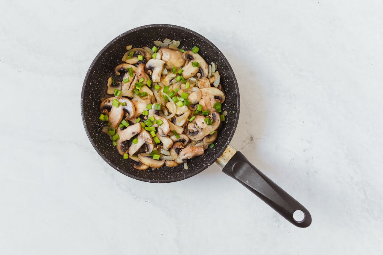 Sauteed mushrooms in a skillet with green peppers