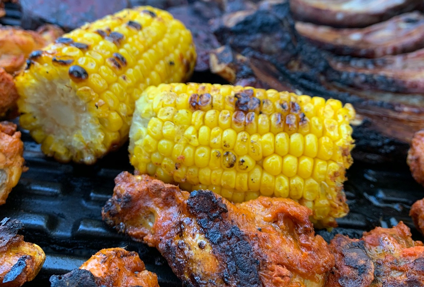 Corn and chicken legs on a grill