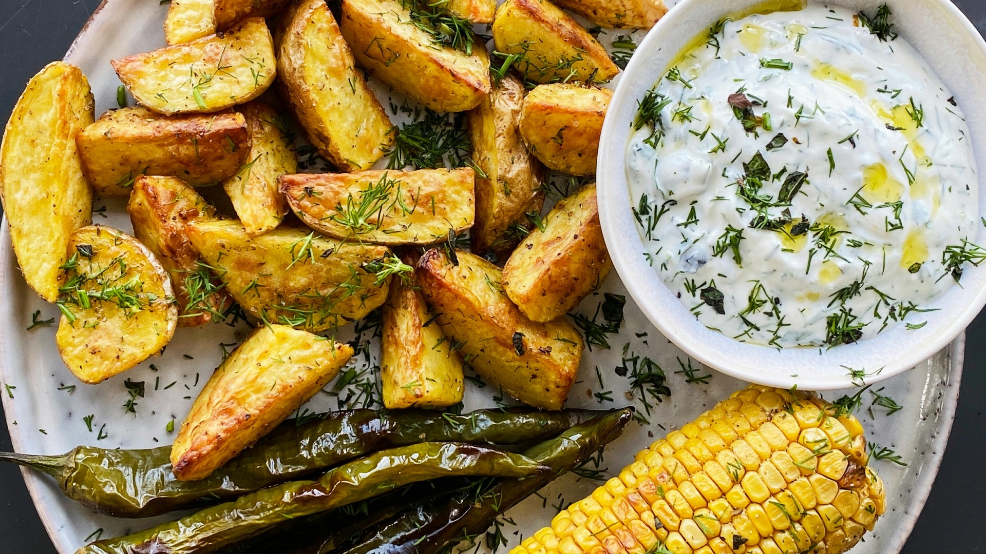 French fries with corn on the cob and green veggies
