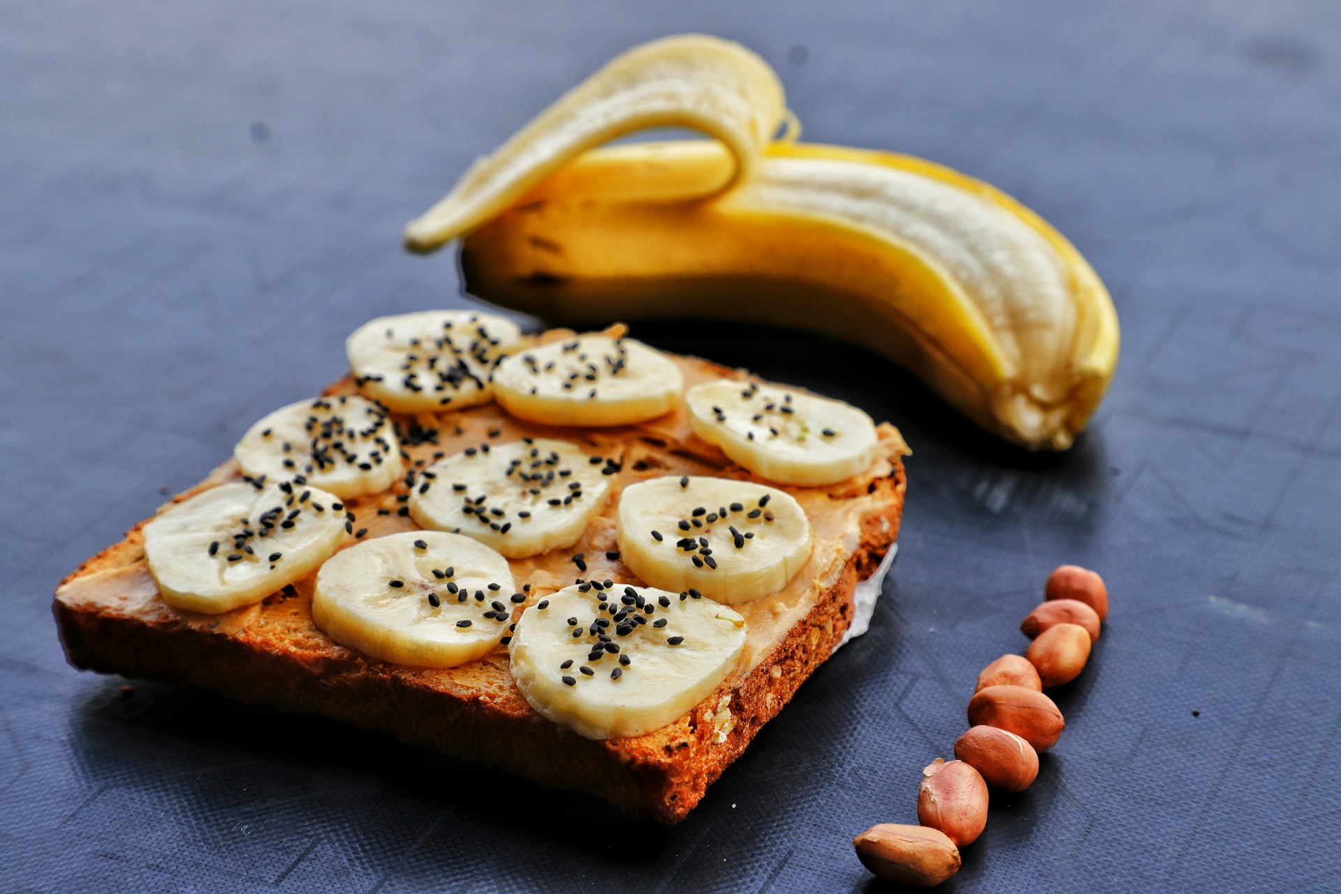 Banana slices on bread with almonds nearby