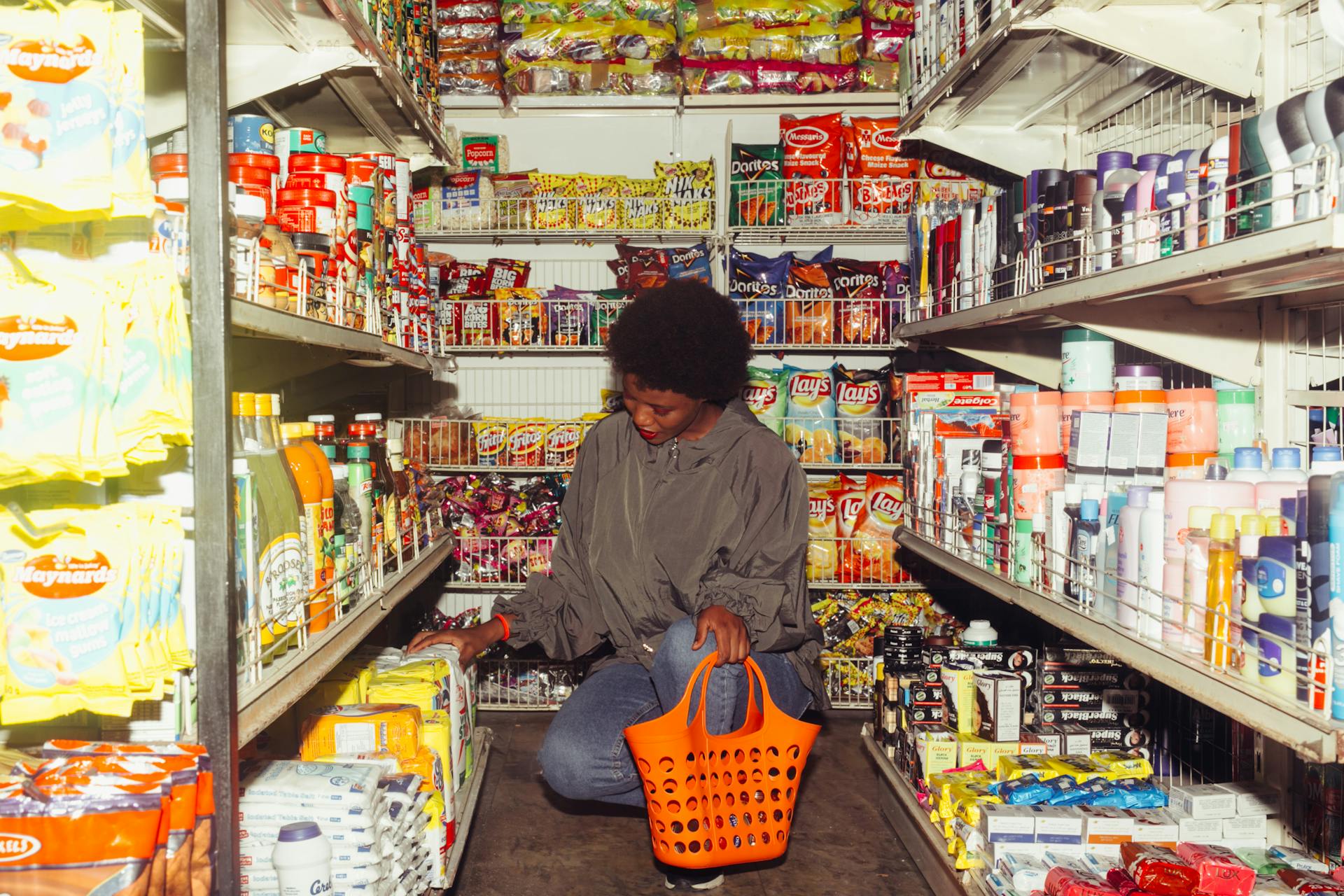 Woman grocery shops in crowded aisle full of dried goods