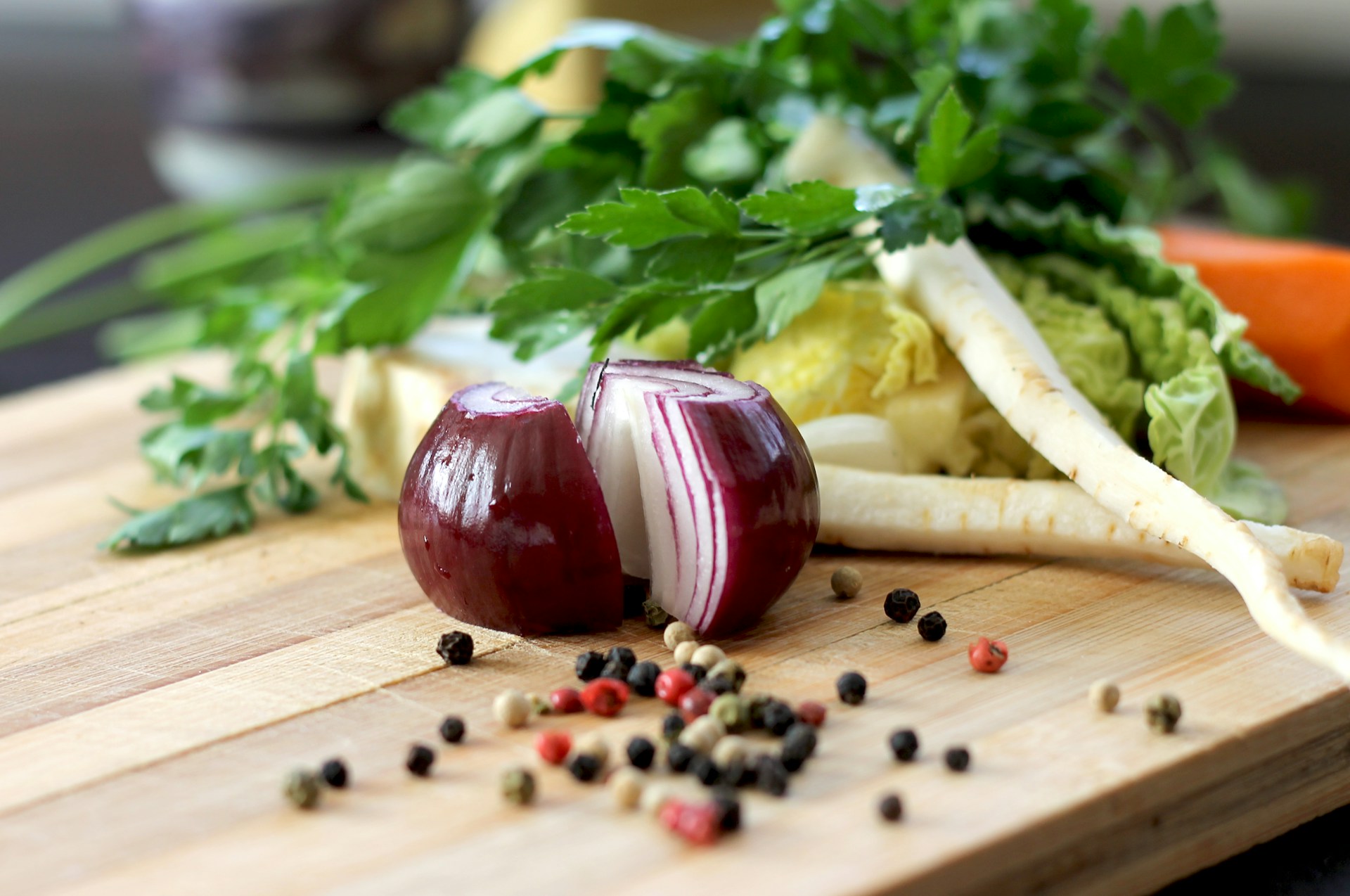 Onions, celery, carrots, black seeds on a cutting board