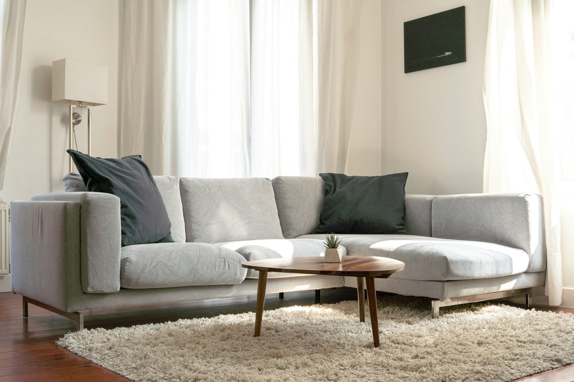 Gray couch with black pillows and coffee table in front of it