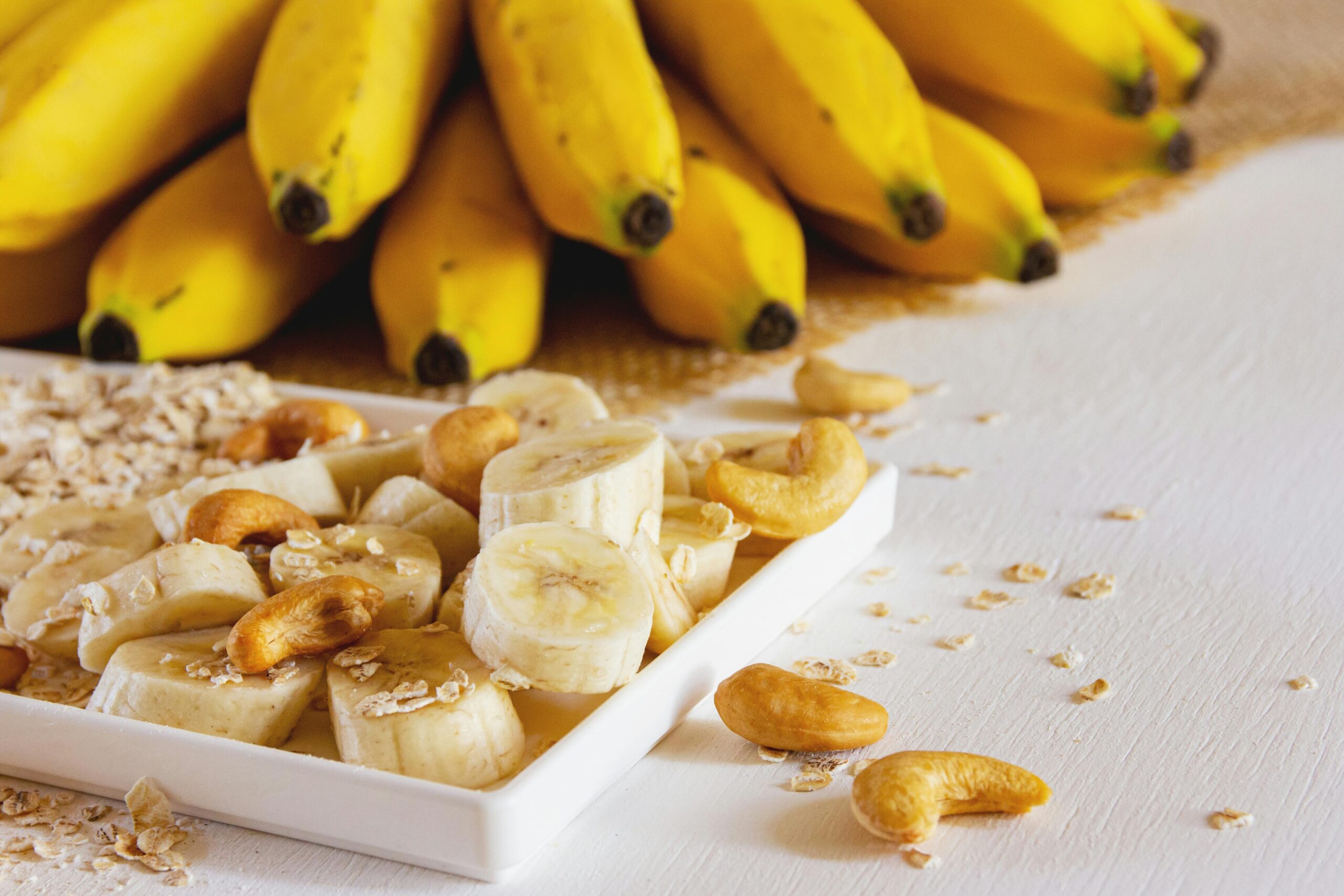 Whole banana peels next to banana slices, nuts and oatmeal