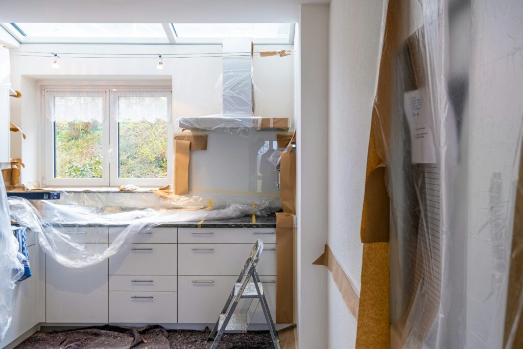 Finishes including a hood vent, cabinets, and countertops are being installed in this home.