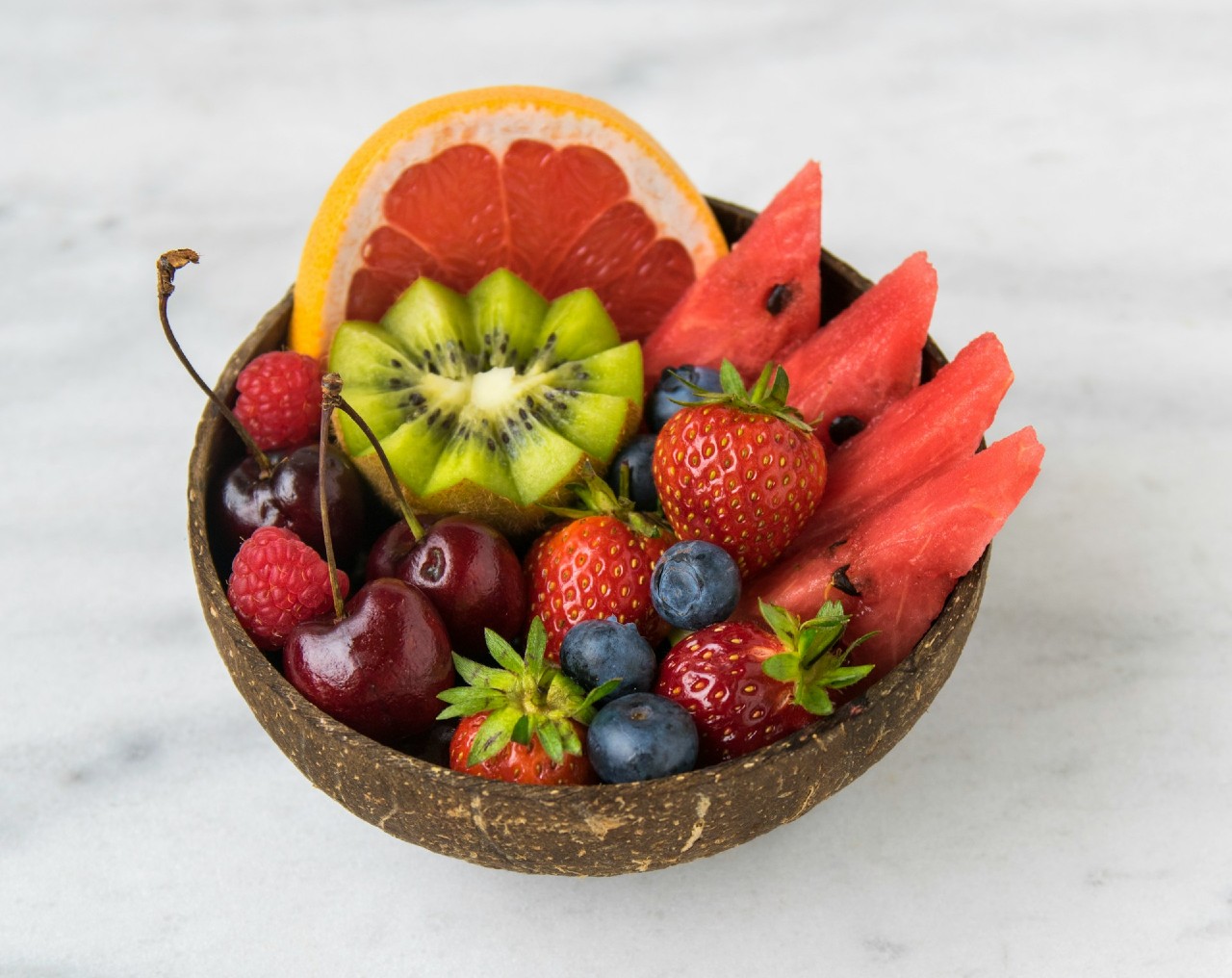 Cut up slices of avocado, strawberries, watermelon, grapes