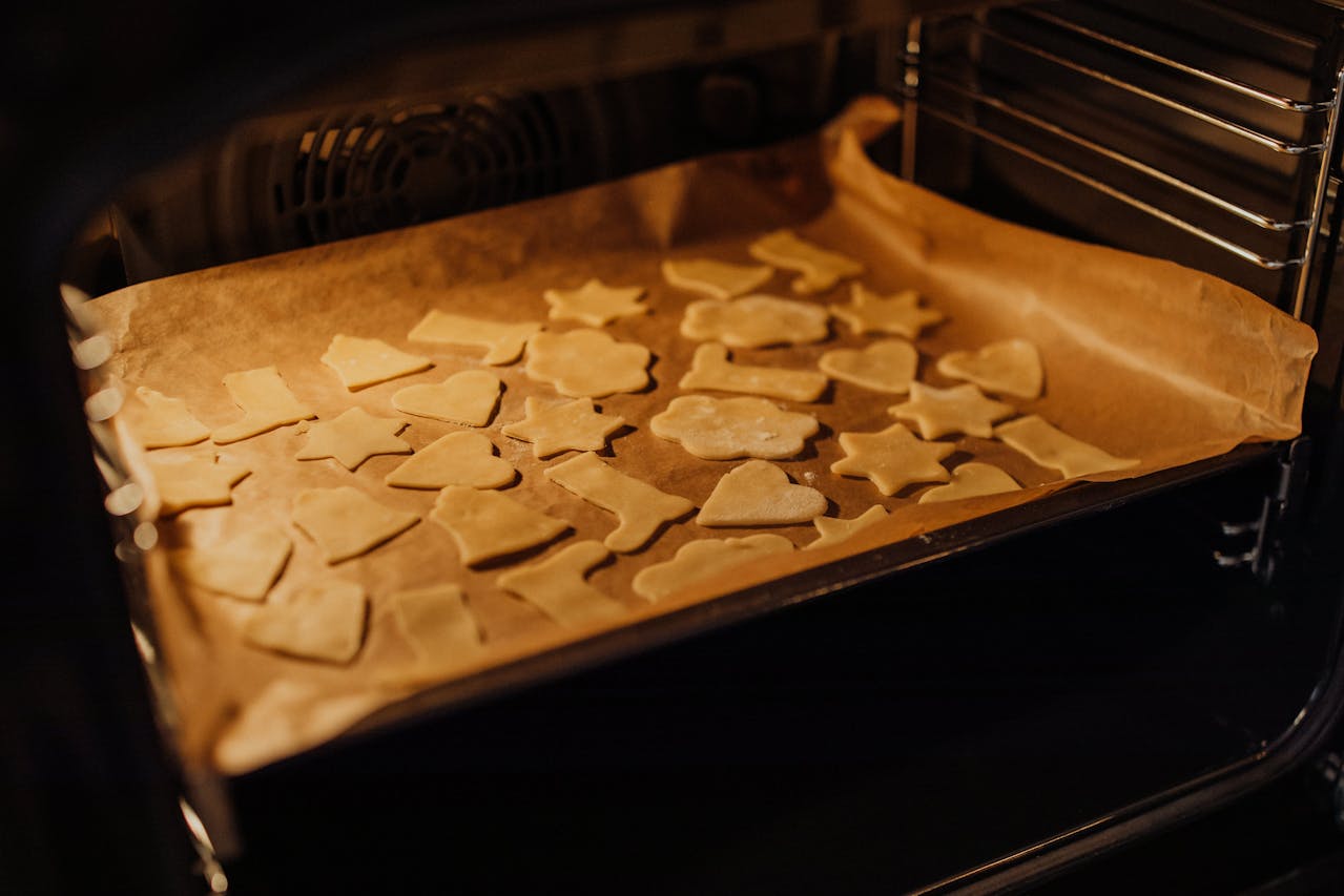 Open oven door with cut-up cookies