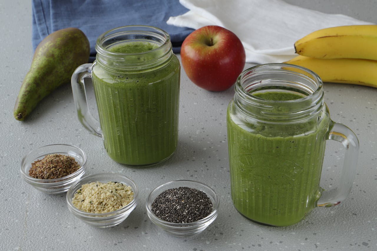 Green fruit smoothie in a glass jar with a handle