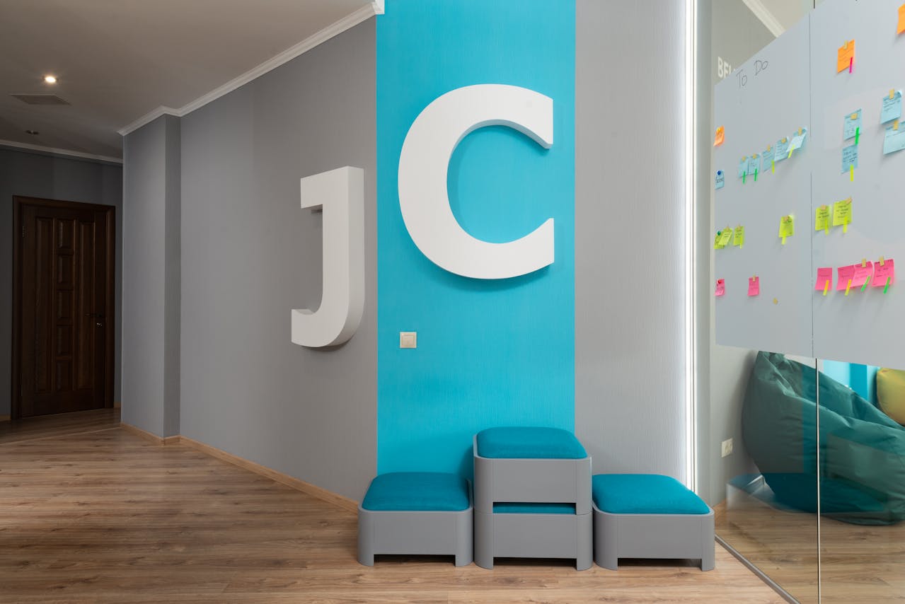 The letters "J" and "C" on a wall outside of an office space