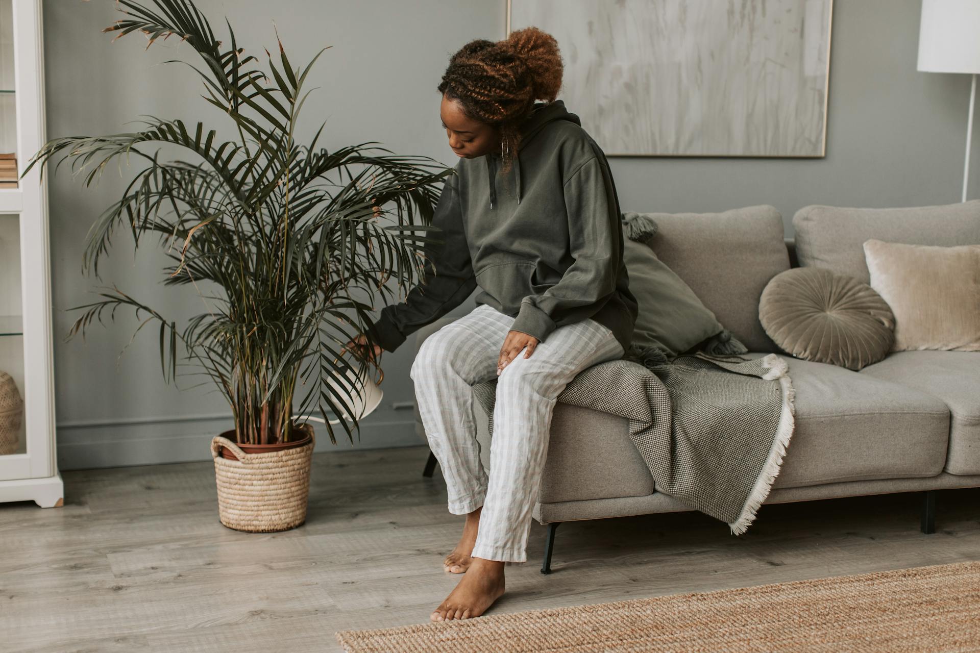 Woman waters large houseplant