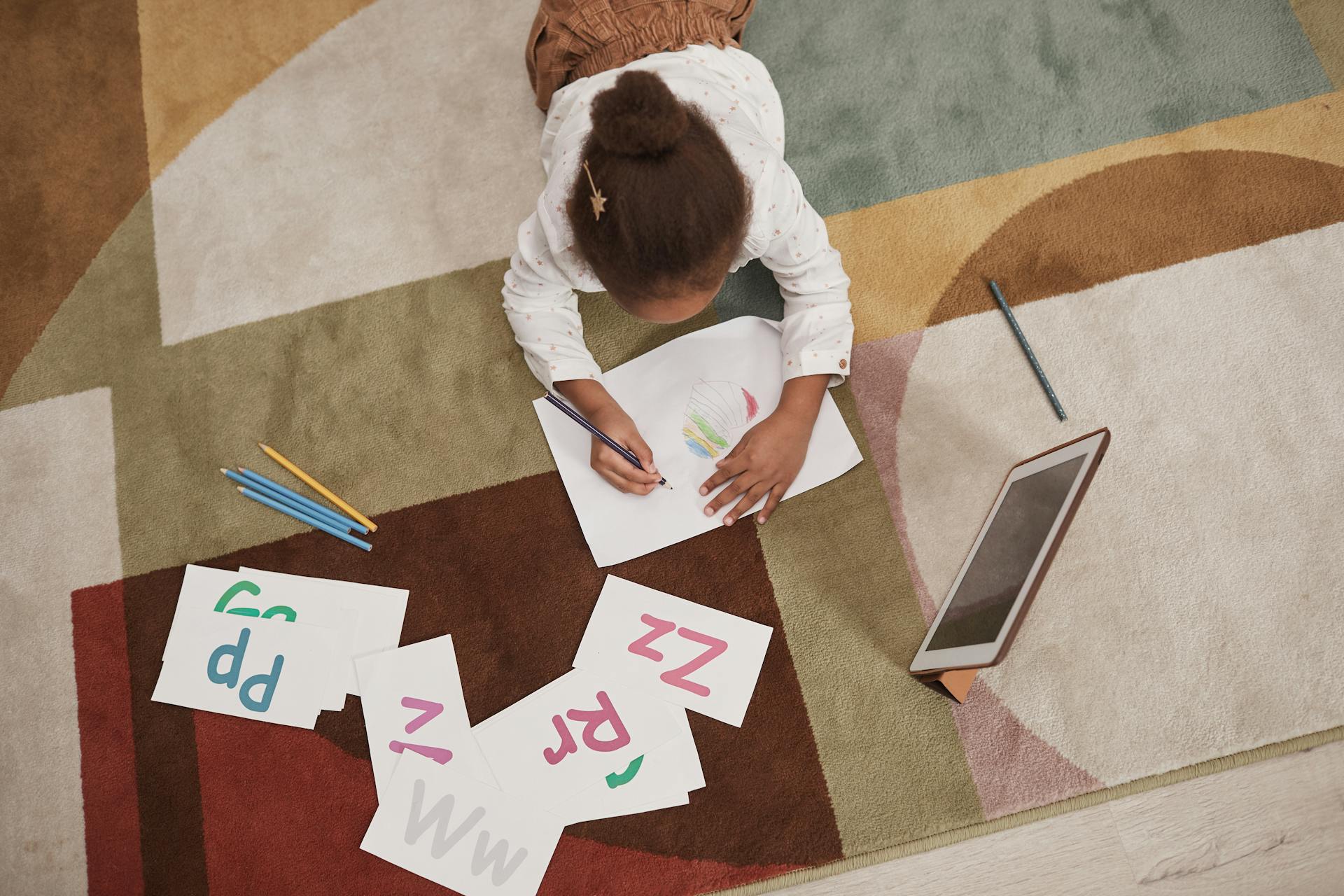 Girl colors on a carpeted floor