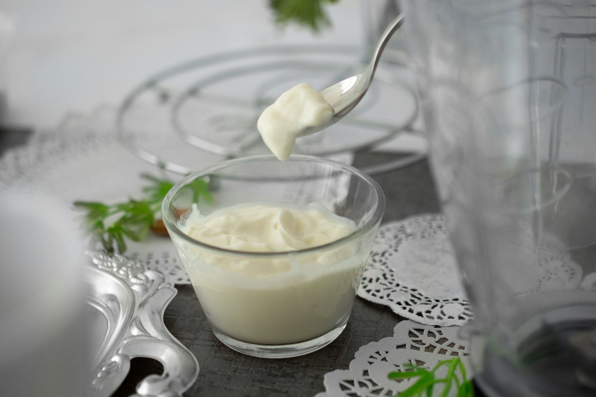 close-up photo of white cream in clear shot glass. Yogurt